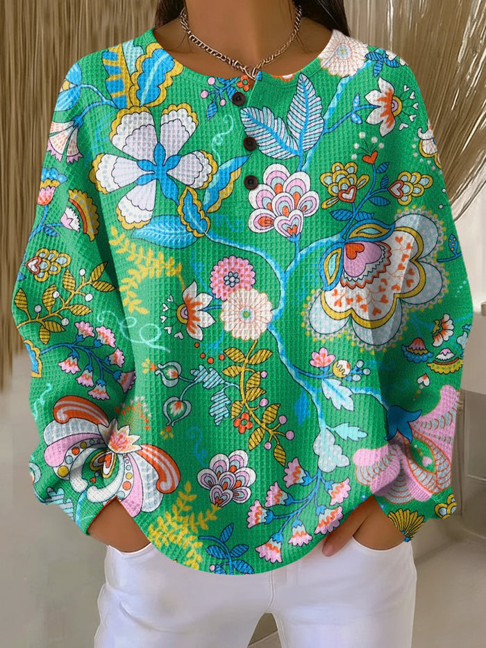 Green women's sweater with colorful ethnic floral print and relaxed fit
