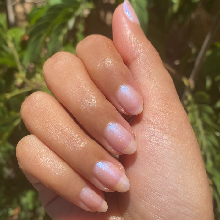 Natural nails with Pink Goldfish sheer iridescent polish showing a subtle luminous shine for an at-home manicure