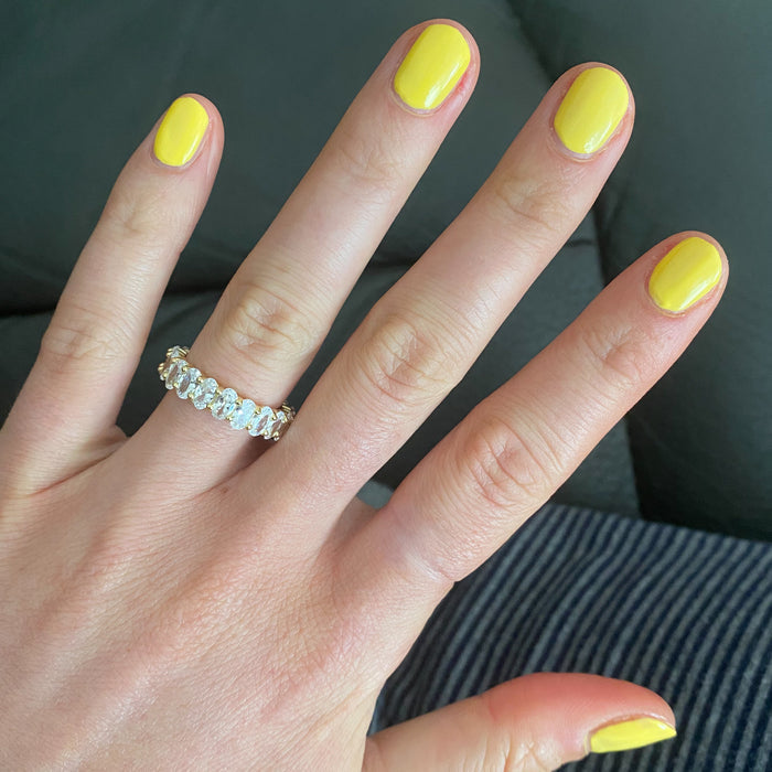 Hand with Bright & Focused yellow gel polish nails and a diamond ring for a vibrant at-home manicure look