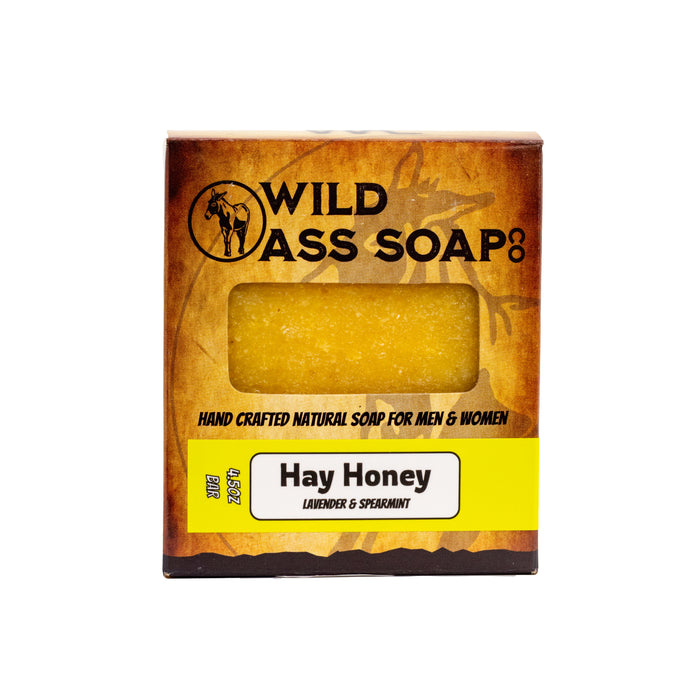 A bar of soap named Hay Honey, with a yellowish hue, packaged in a cardboard box with branding and product information.