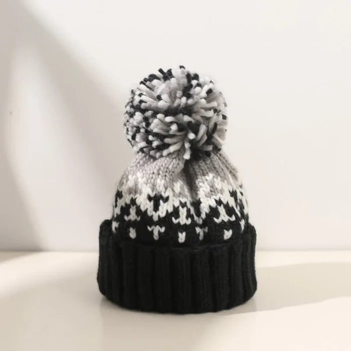 Cozy knit snowflake beanie with fluffy pom-pom shown in multiple colors