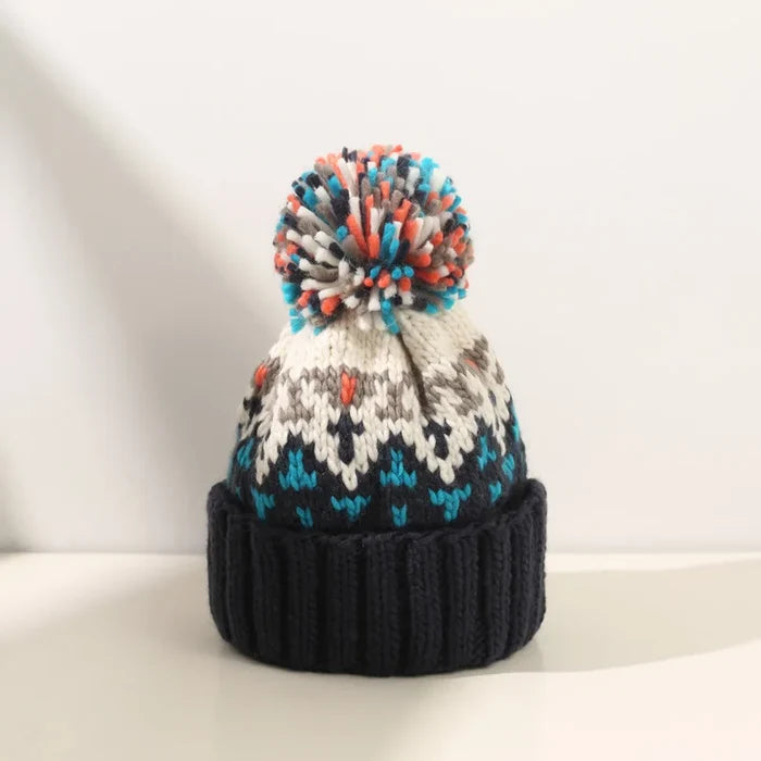 Cozy knit snowflake beanie with fluffy pom-pom shown in multiple colors