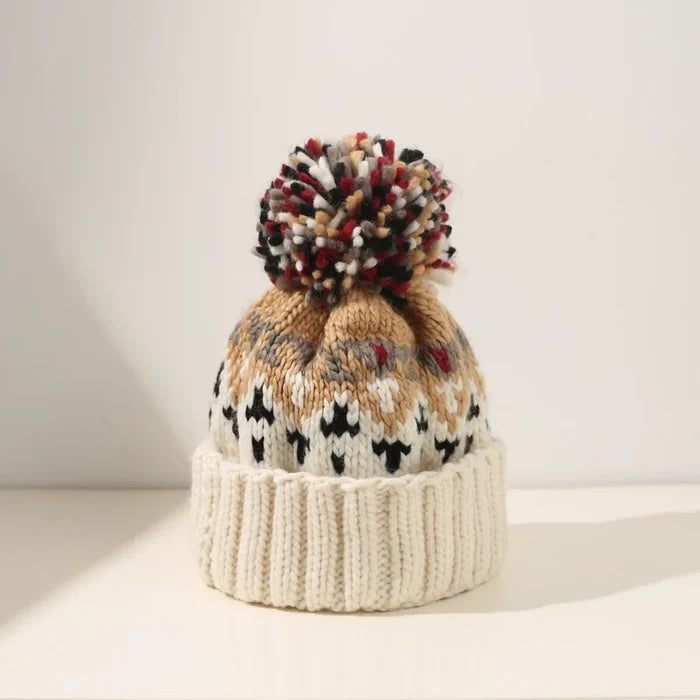 Cozy knit snowflake beanie with fluffy pom-pom shown in multiple colors