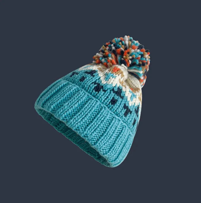 Cozy knit snowflake beanie with fluffy pom-pom shown in multiple colors