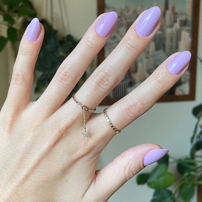 You're Invited - Press-On | Medium | Almond showing hand with playful lilac purple medium almond press-on manicure and gold rings