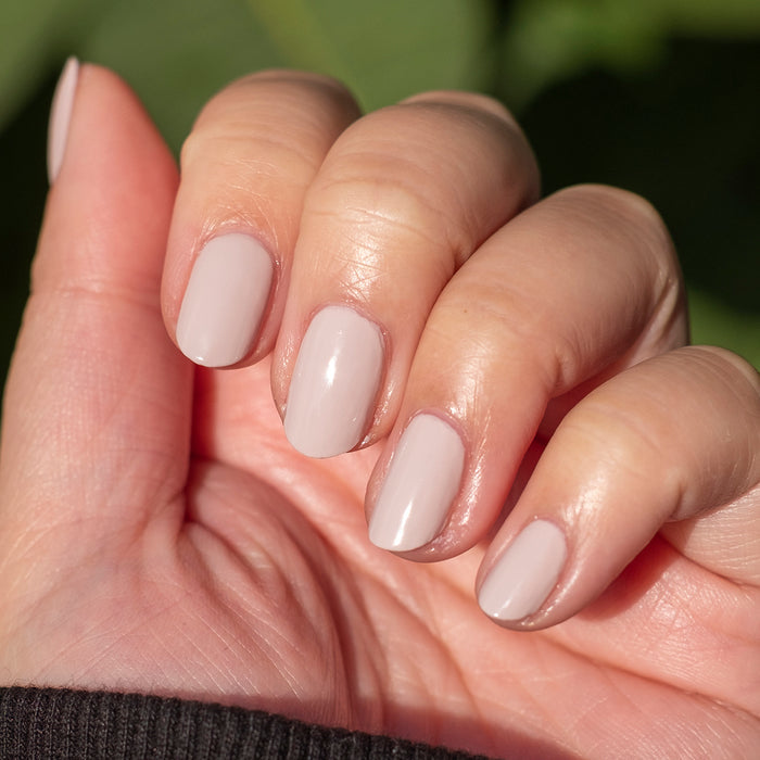 Hand with nails polished in CDJ showing a smooth, creamy neutral gel polish ideal for at-home manicure polish lovers